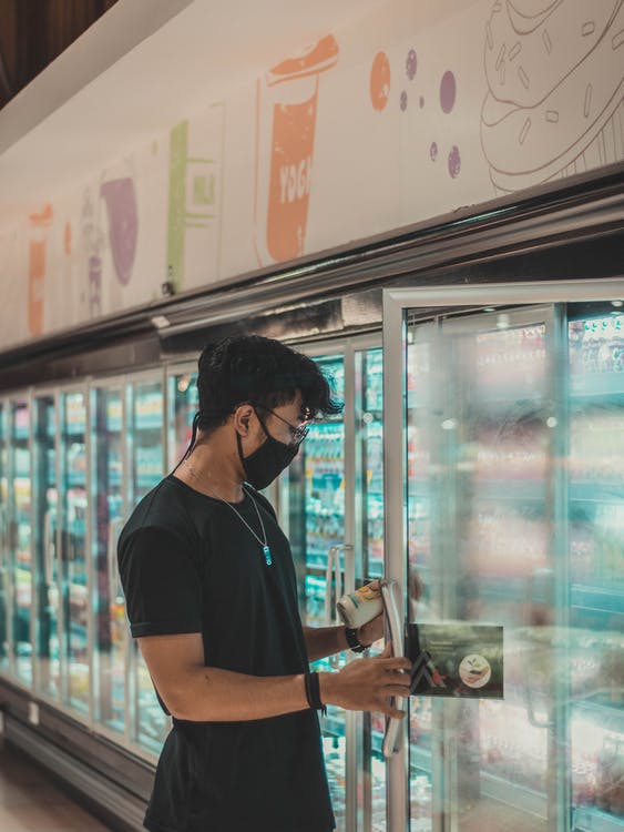 a boy using a commercial refrigerator