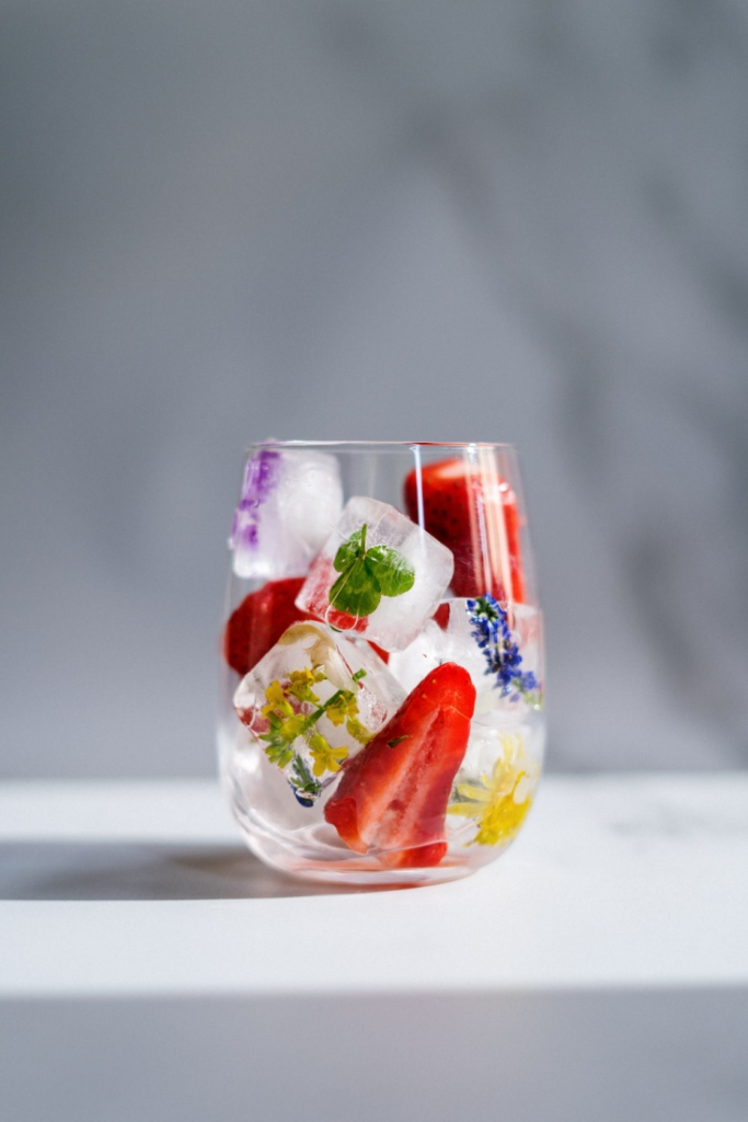 A glass filled with fruits and ice cubes