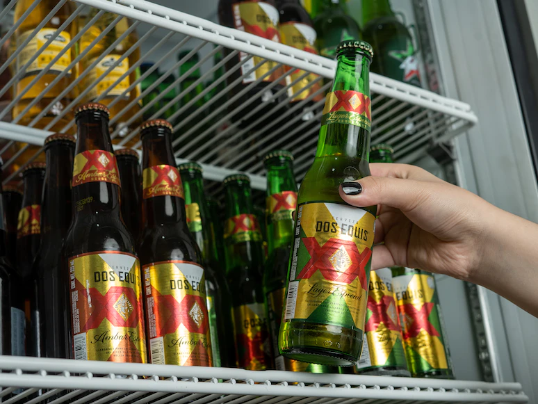  A person taking out a beer from a refrigerator 