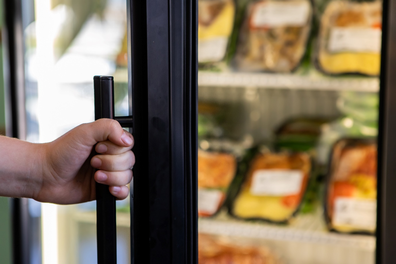 Person opening refrigerator door