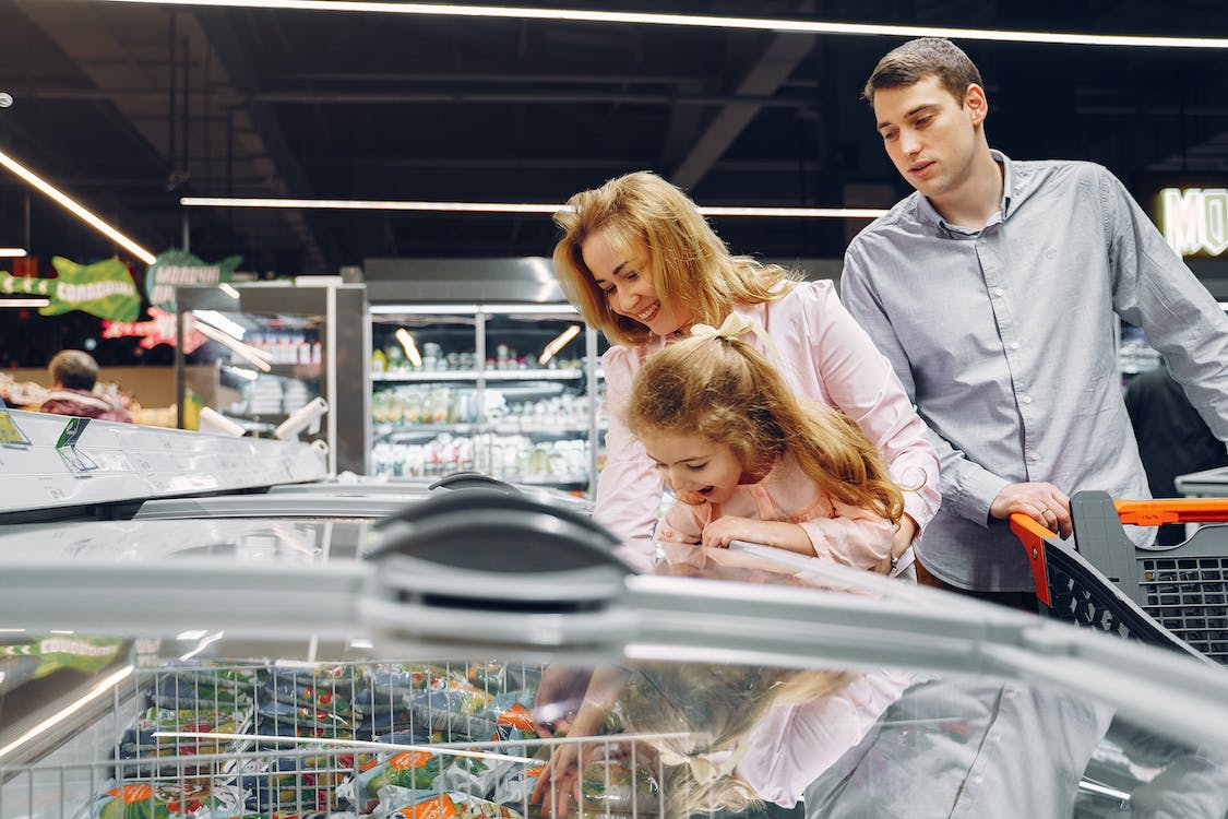 A family picking out ice cream from a commercial freezer