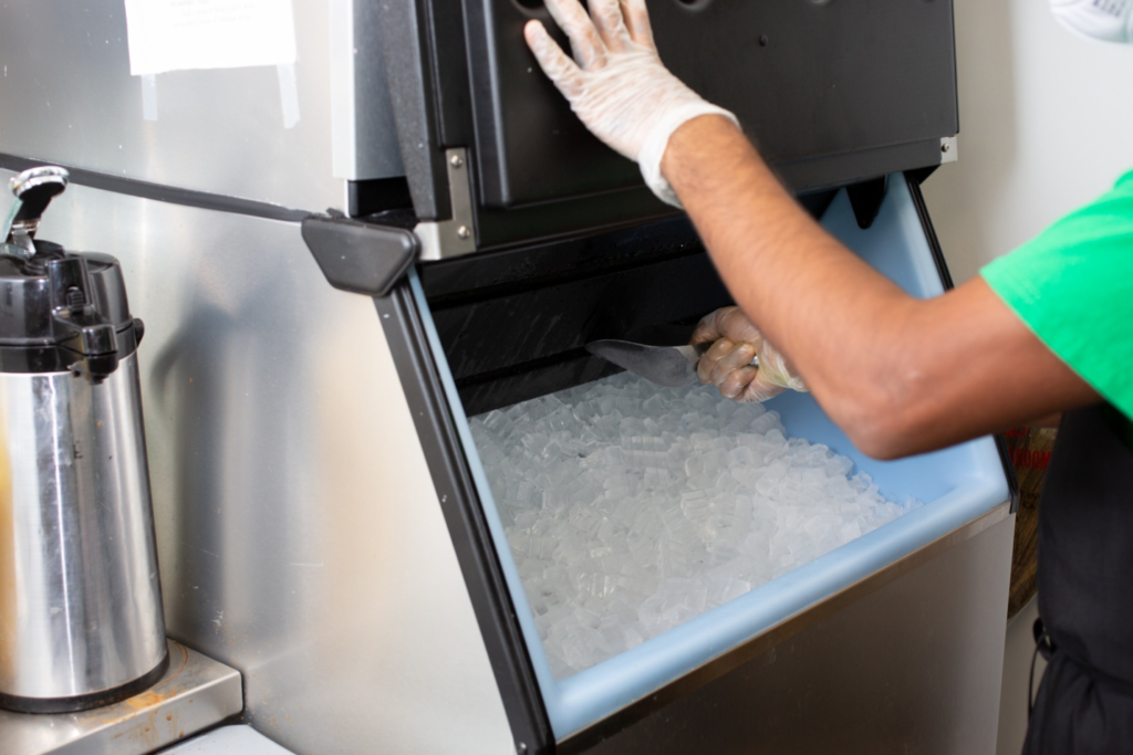 A person taking out ice cubes from an ice machine