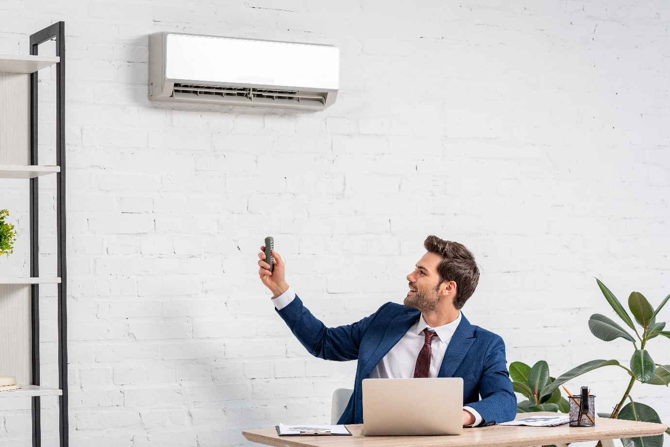 A man switching on an air conditioner
